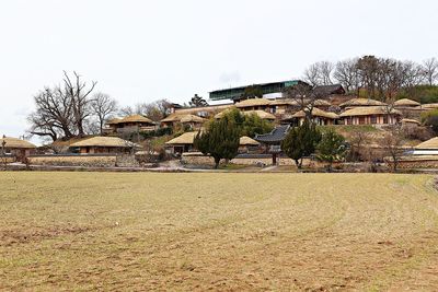 Houses on field against clear sky