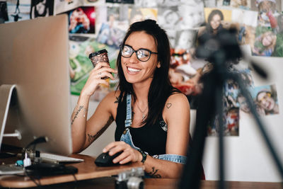 Portrait of smiling woman sitting on table