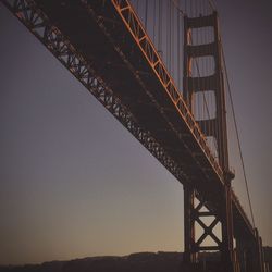 Low angle view of golden gate bridge against clear sky during sunset