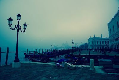 Cars on illuminated street against sky at night
