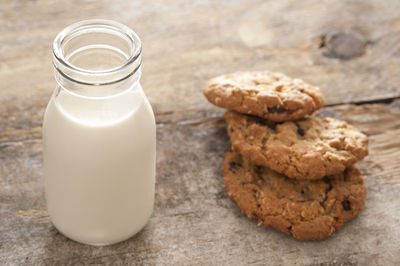 Close-up of milk bottle and cookies on table