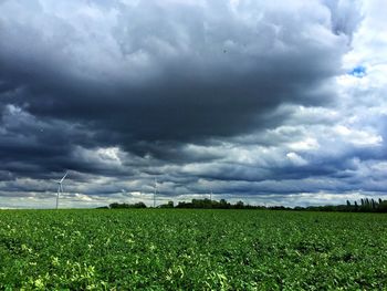 Scenic view of field against cloudy sky