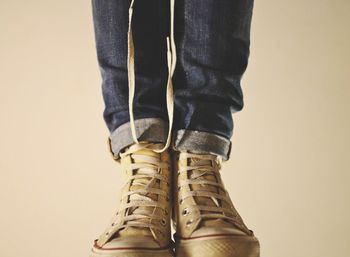 Low section of man standing against white background