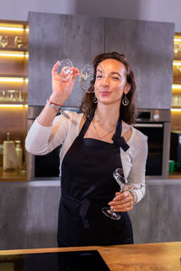 Portrait of smiling young woman drinking wine in cafe