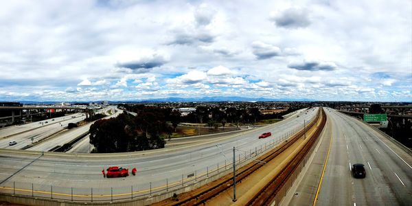 High angle view of vehicles on road against cloudy sky