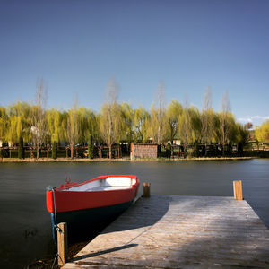 Boat moored in lake against clear sky