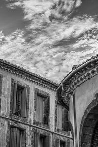 Low angle view of old building against cloudy sky