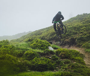 Man riding bicycle on a trail downhill