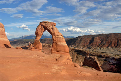 Rock formations on landscape against cloudy sky