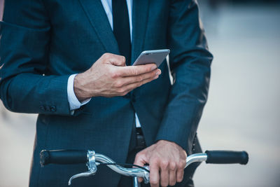 Midsection of man using mobile phone