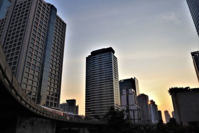 Low angle view of modern buildings against sky during sunset