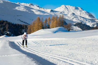 Woman in a cross-country skiing on the tracks