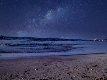 Scenic view of beach against clear sky at night