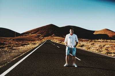 Portrait of man standing on mountain against clear sky