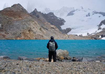 Rear view of man standing on rock