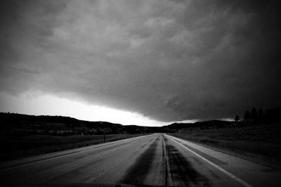 Country road against cloudy sky