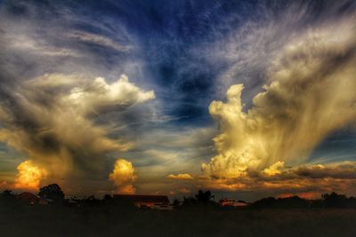 Storm clouds over landscape during sunset