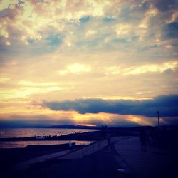 Scenic view of sea against cloudy sky at sunset