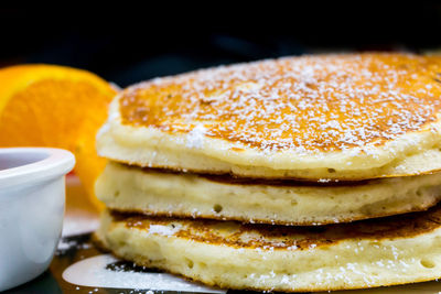 Close-up of pancakes garnished with powdered sugar on table