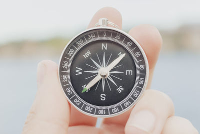 Close-up of hand holding navigational compass