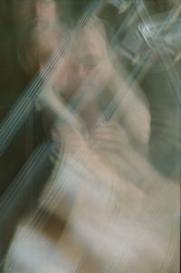 Close-up portrait of woman seen through glass window