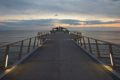 Pier over sea against sky during sunset