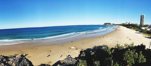 Scenic view of beach against clear blue sky