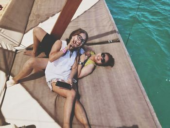 High angle view of smiling couple lying on boat