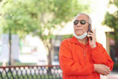 Portrait of man standing on smart phone outdoors