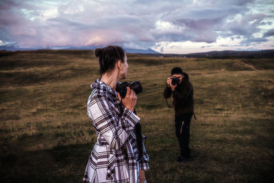 Friends standing on land against sky