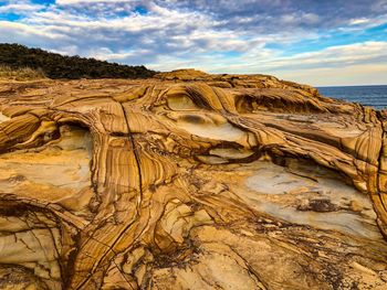 Rock formation in sea against sky