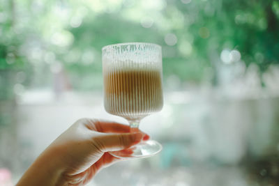 Close-up of hand holding glass against blurred background