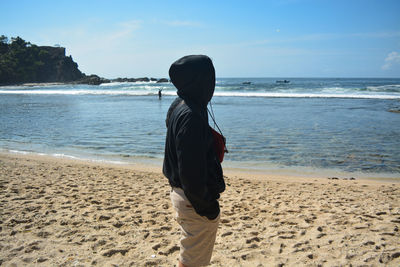 Rear view of man standing on beach