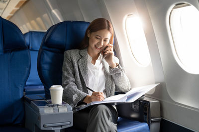 Businesswoman with documents working in airplane