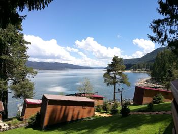Scenic view of swimming pool by lake against sky