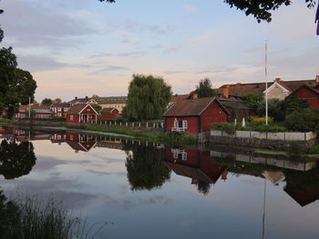 Scenic view of lake by buildings against sky