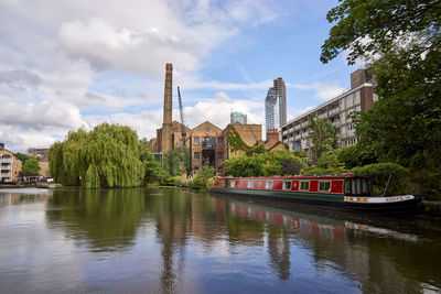 Scenic view of river by buildings against sky