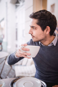 Young man drinking coffee at home