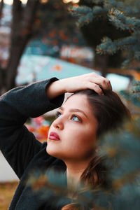 Close-up portrait of young woman looking up