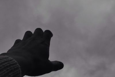 Low angle view of hand against sky