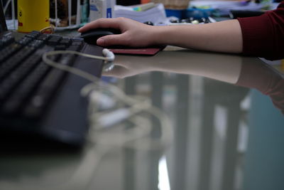 Close-up of person hand using computer mouse on table