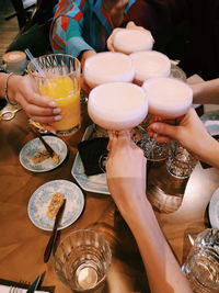 Midsection of woman holding coctails on table