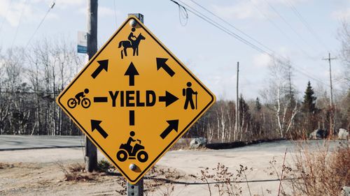 Close-up of road sign against sky during winter