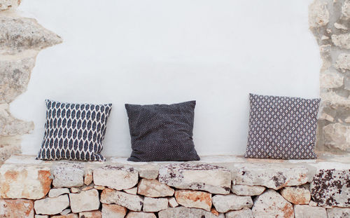 Black and white geometric pillows near a wall on a patio