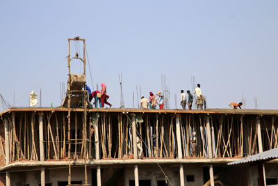 Low angle view of workers at construction site against sky