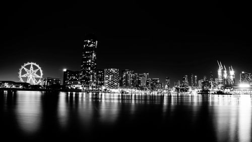 Illuminated modern buildings against clear sky at night