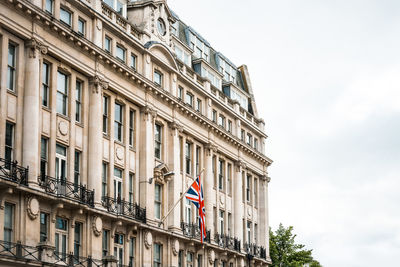 British flag on building against cloudy sky