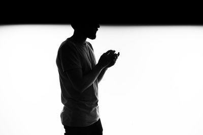 Side view of silhouette woman against white background