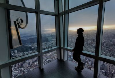 Man looking through window in city