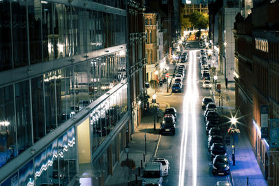 High angle view of vehicles on road along buildings